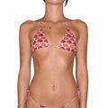 A model wearing a two-piece bikini with a pink and red scallop shell pattern, shown against a plain white background.
